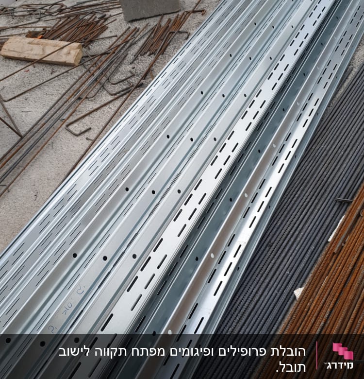 קורות מתכת מונחות באתר בנייה על הקרקע